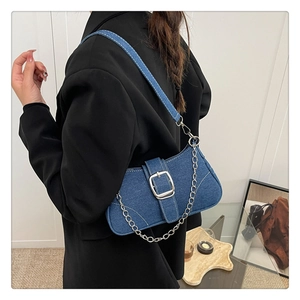 Dettaglio della borsa a spalla in denim blu con fibbia argento e catena decorativa
