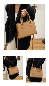 Detail view of the khaki pebbled leather handbag featuring white fashion lettering print