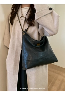 Detail der Retro-Stepptasche mit goldener Kette und metallischem Drehverschluss