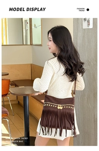 Détail du sac cabas à franges marron foncé avec clous dorés porté par un mannequin de profil