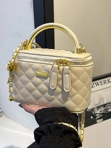 Quilted cream chain bag with gold metal handle and dual zippers in minimalist style