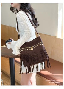 Vue détaillée d'un sac bandoulière en daim marron avec de longues franges et métal doré