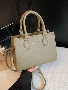 Chic khaki litchi leather tote bag with dual handles and gold hardware in office setting