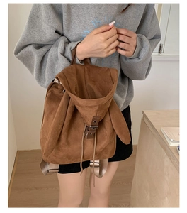 Detail of a brown faux suede backpack featuring cute rabbit ear design and drawstring