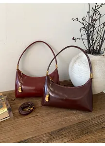 Close-up of semi-circle leather shoulder bags in burgundy and brown on a retro desk