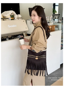 Détail du sac cabas en daim noir avec franges et clous dorés de style bohème chic