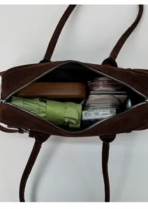 Spacious dark brown suede underarm bag showing interior capacity for daily essentials