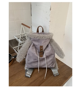 Detail view of the gray hoodie backpack with faux fur sleeves and leather strap closure