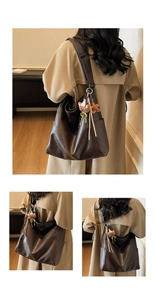 Gros plan détaillé du sac cabas en similicuir marron foncé avec charm d'ours peluche