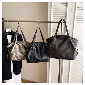 Detailed trio of large leather tote bags in champagne, black, and dark brown finishes