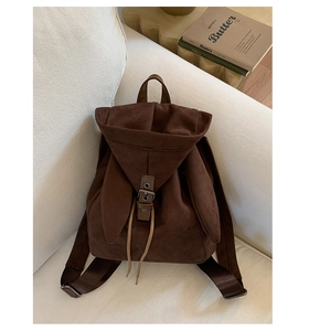 Detail of dark brown faux suede backpack with cute rabbit ear flaps and buckle closure