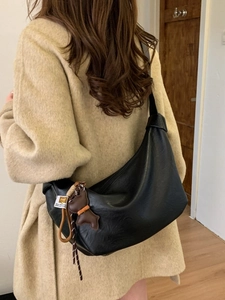 Black pleated hobo bag for women with cute puppy charm and stylish woven strap detail