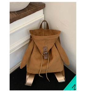 Detailed close-up of dark brown faux suede texture and unique wing-style backpack side design