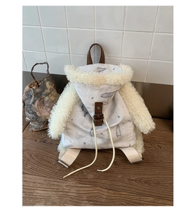 Detail of plush fleece cartoon backpack with faux leather handle and canvas texture
