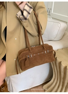 Detail of vintage brown suede shoulder bag with metal eyelet belts and silver hardware