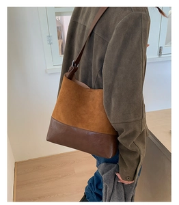 Retro brown bucket bag in textured suede and smooth leather shown on model's shoulder