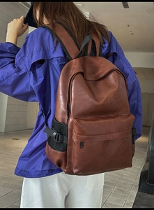 Side view of a vintage brown PU leather backpack with mesh pocket and large main compartment