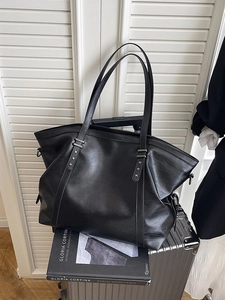 Minimalist black faux leather tote bag with silver star accents and long shoulder strap