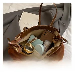 Internal storage view of a large brown suede tote bag showing space for phone and makeup