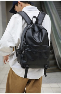 Outdoor shot of a black vintage PU leather backpack with buckle details and side straps