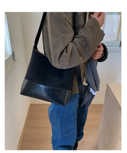 Detailed shot of large black tote bag with contrasting suede and leather textures