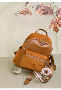 Detail of caramel brown backpack featuring diamond quilted pocket and cute sheep charm