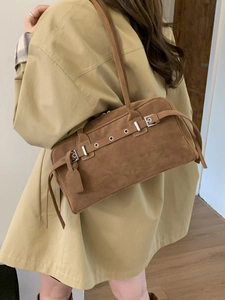 Retro brown suede underarm pillow bag with metal eyelets worn with a trench coat