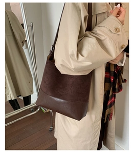 Detail of dark brown bucket bag featuring a mix of matte suede and smooth leather textures