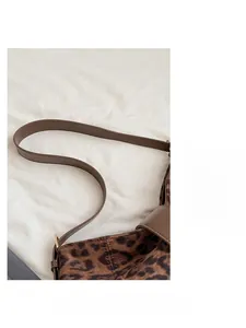 Gros plan sur la bandoulière en cuir et l'imprimé léopard de ce sac à bandoulière élégant