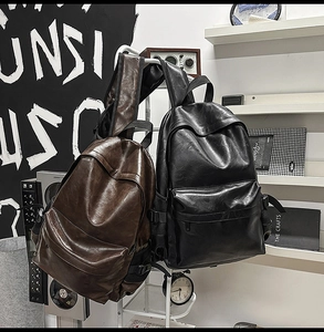Close-up of vintage PU leather backpacks in black and brown on a minimalist display