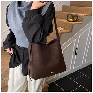 Close-up of vintage dark brown tote bag showing matte texture and gold logo detail