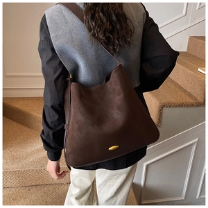 Macro view of dark brown frosted suede hobo bag with gold metal oval hardware detail