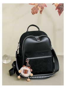 Detail of black patchwork leather backpack with quilted suede and white lamb charm