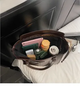Spacious interior of retro brown tote bag with tablet, phone, and daily essentials