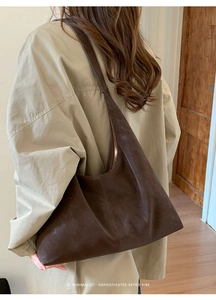 Deep brown oversized retro tote bag worn by a model in a minimalist khaki trench coat