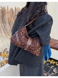 Sac à bandoulière léopard avec lanière en cuir marron porté par un mannequin en extérieur