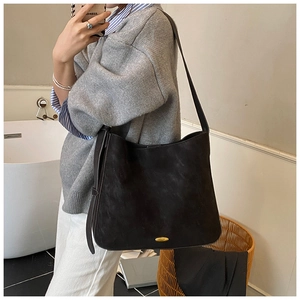 Detail of a large black vintage matte tote bag with elegant gold metal buckle hardware
