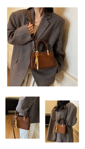 Close-up of minimalist suede handbag featuring embossed branding and a woven handle