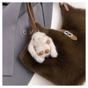 Detail of brown faux fur tote bag with leather strap and cute white plush bunny charm
