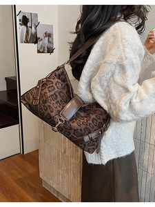 Vue arrière d'un sac à bandoulière léopard porté par un mannequin dans un décor intérieur