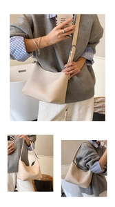 Macro detail of beige lychee texture leather on a minimalist crescent hobo shoulder bag