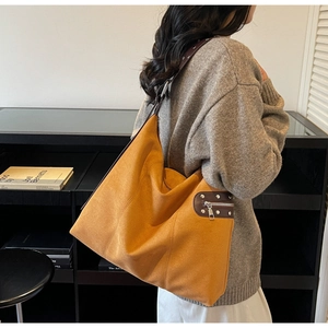 Detail of ginger suede tote bag with rivets and side zipper in bohemian retro style