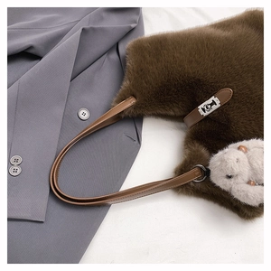 Detailed top view of brown faux fur tote bag with silver buckle and rabbit charm