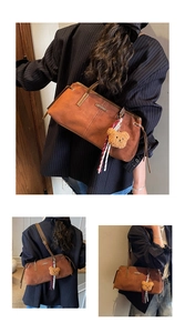 Detail of vintage brown faux suede shoulder bag with plush bear charm and striped ribbon