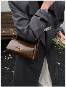 Brown gloss leather shoulder bag featuring a vintage gold twist lock in a street style setting