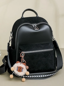 Women's black quilted fashion backpack with stylish woven strap and plush charm accent