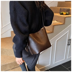 Brown bucket bag with retro textured finish and silver metal buckle on side