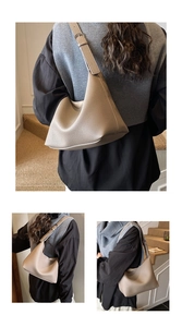 Detailed close-up of khaki pebbled leather texture and silver buckle on bucket bag