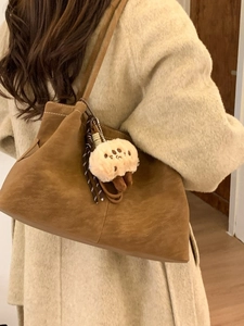 Brown faux suede tote bag with plush charm and woven strap, perfect for women's daily commute