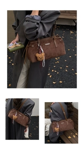 Detailed view of deep brown suede tote bag with vintage hardware and cute bear pendant